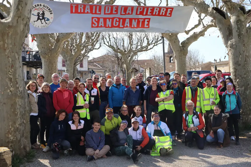 Photo de groupe des bénévoles sous la banderole du trail